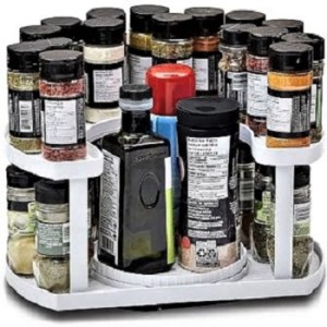 A white plastic two-level spice rack with a variety of spices and containers.