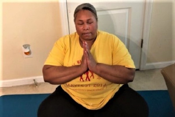 Empish sitting on mat in a yoga prayer pose