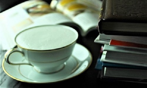 Books on desk with cup of tea