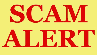 Inside a sign with a yellow background and red border are The words "SCAM ALERT" in bold red letters.