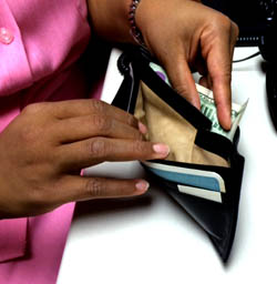 Hand placing dollar bills in wallet