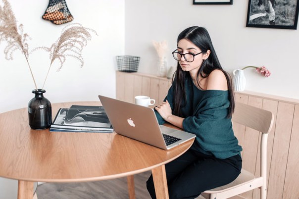 Woman sitting at table using a laptop to look for a job
